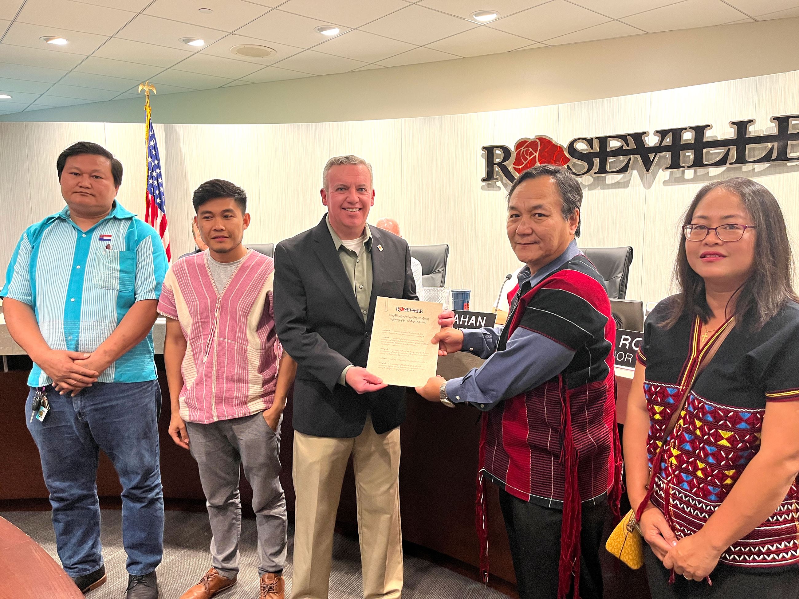 Four members of the Karen community, and Mayor Dan Roe stand for acceptance of proclamation.