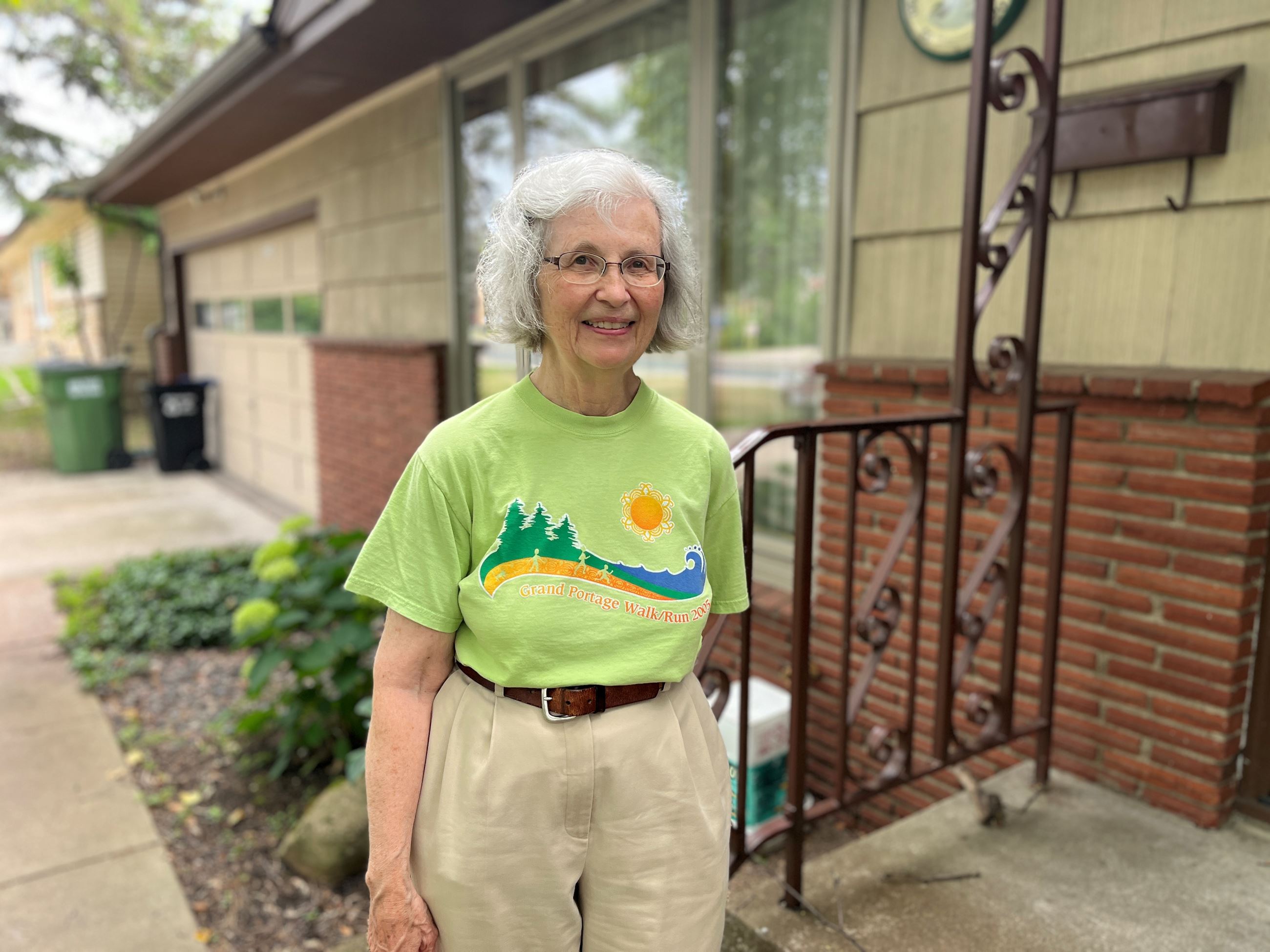 Thelma Boeder stands in front of the home she sold to become part of the land trust partnership.