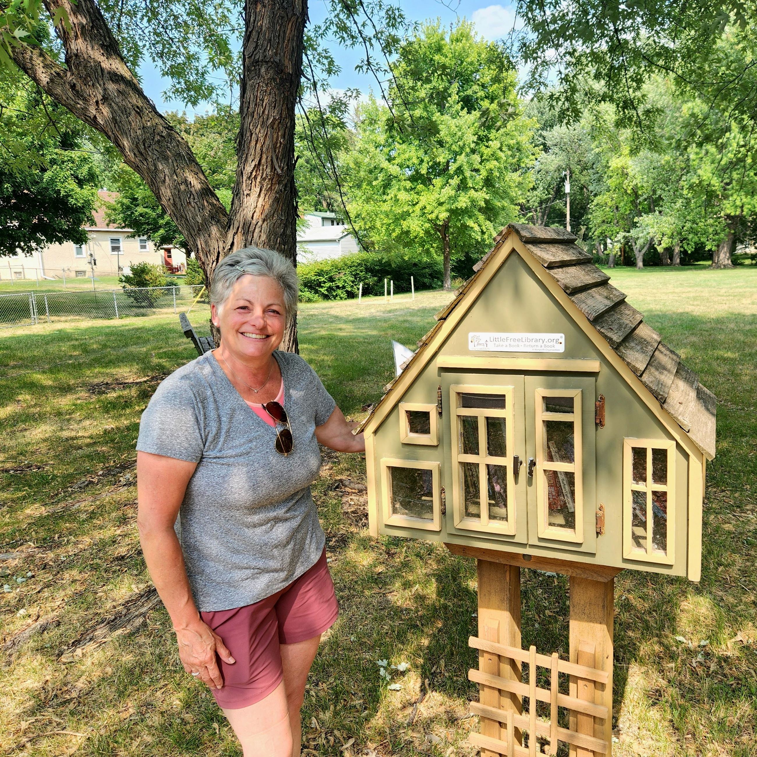 A Roseville residents stands in front of the "Little Free Library" at Keller Mayflower Park.