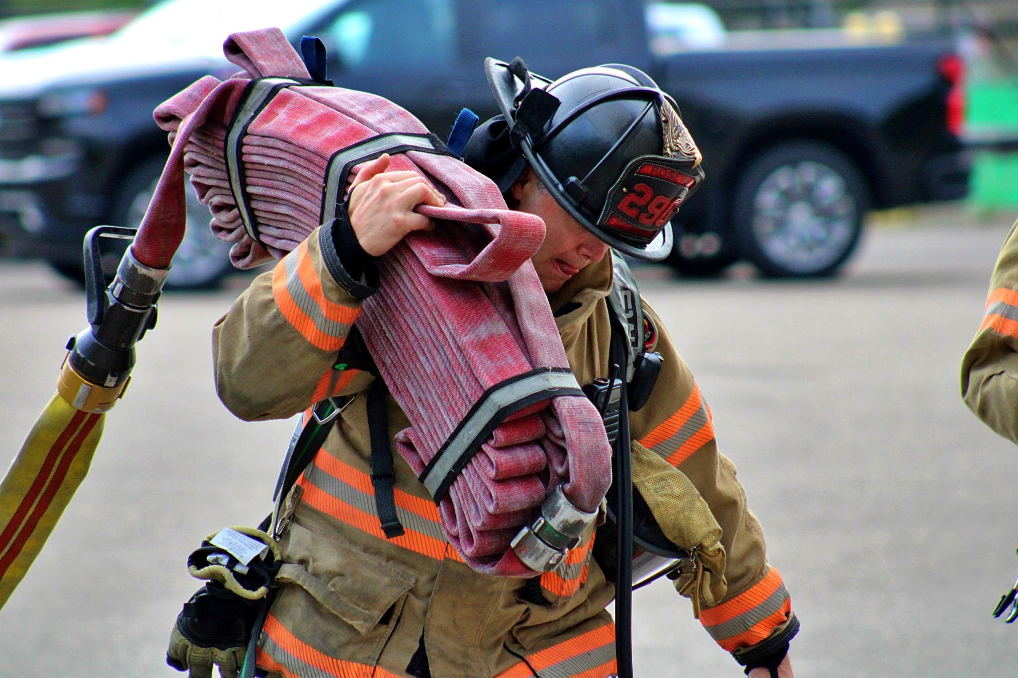 A Roseville Firefighter loads a hose.
